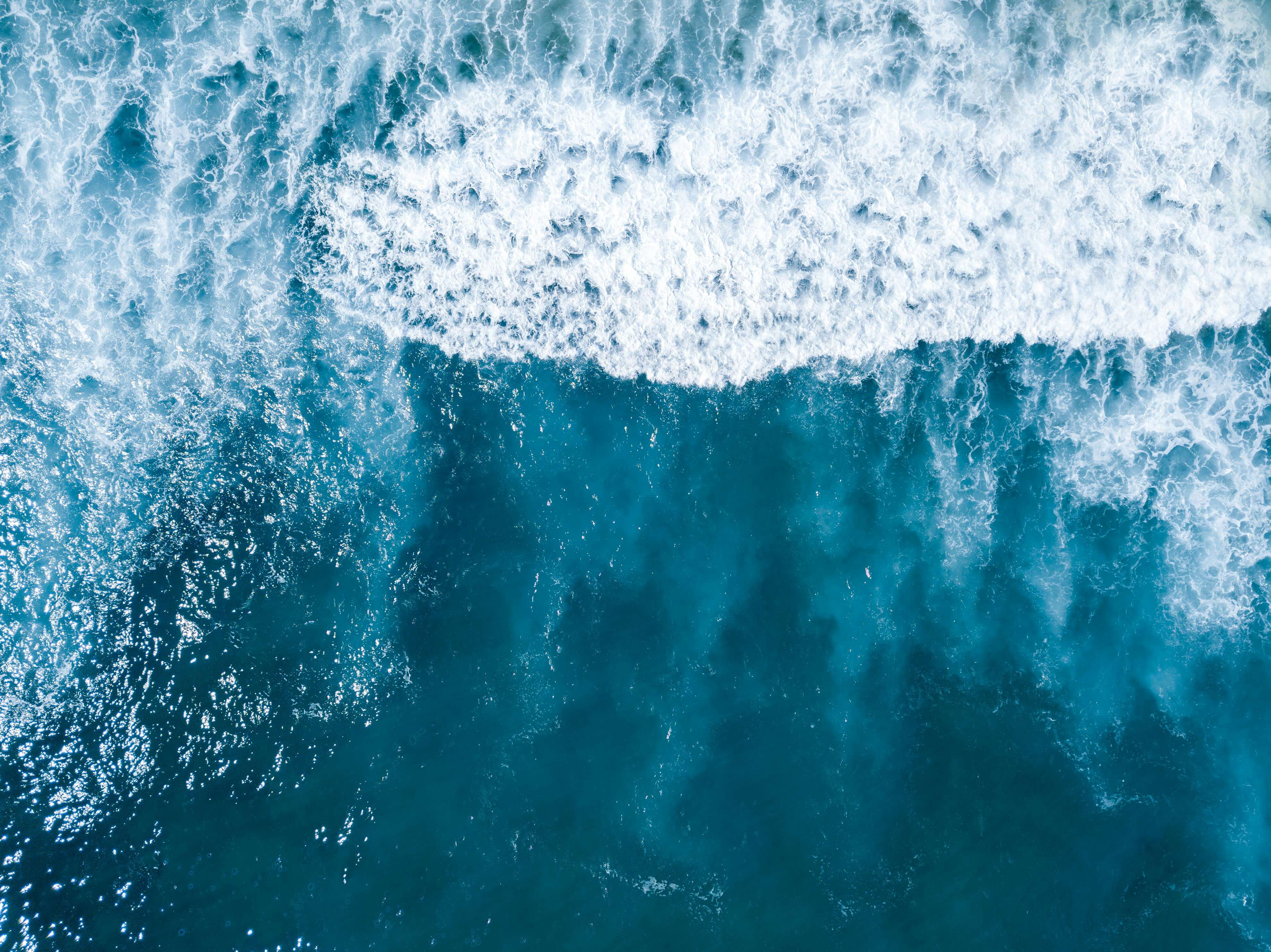 Kraftvolle blaue Wellen im Meer die sich ueberschlagen